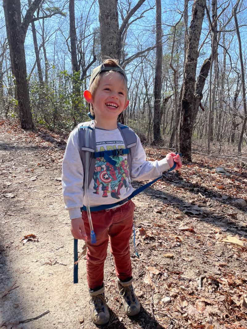 child hiking in the woods smiling 