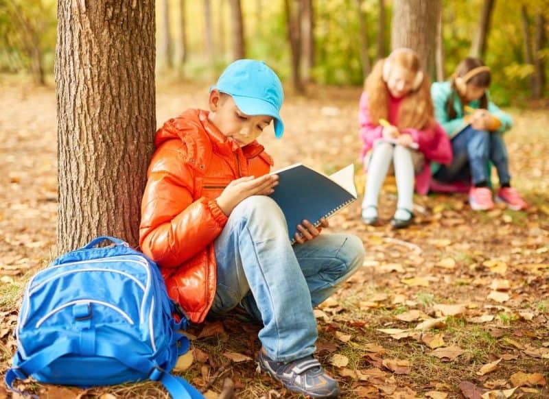Kids in the woods doing outdoor learning activities 